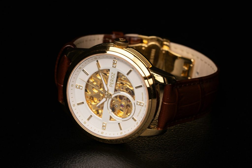 A gold watch with a leather strap.